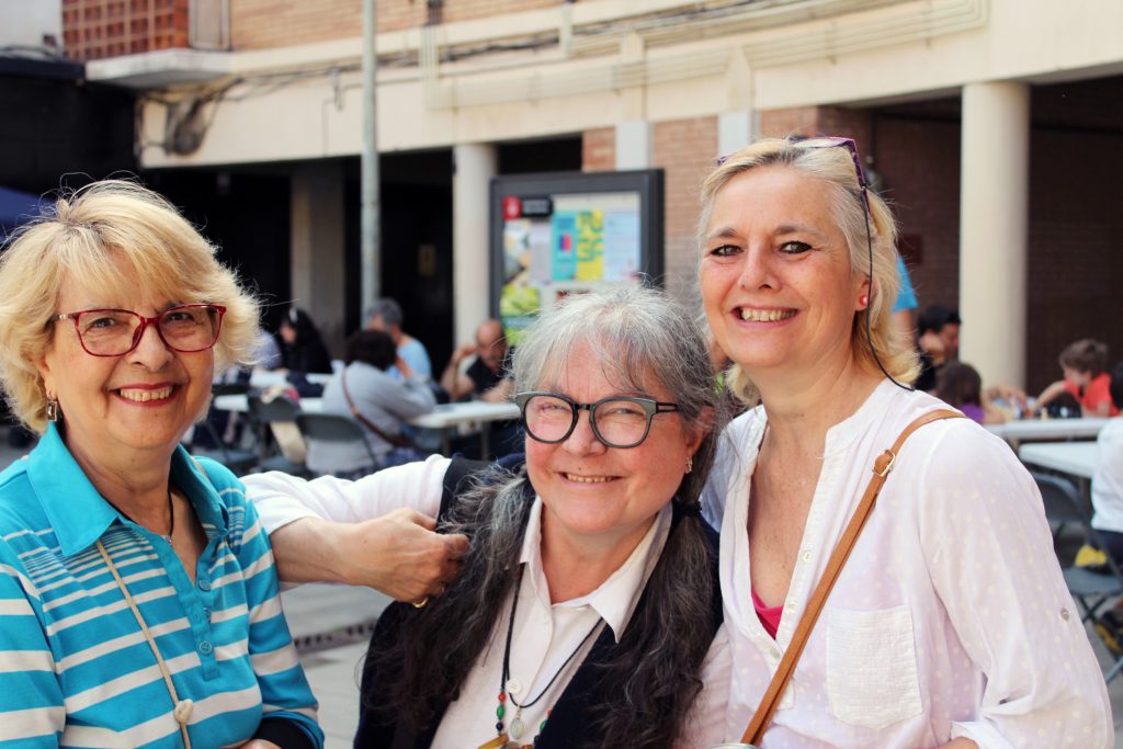 Tres persones grans somriuen a la càmera a la I Festa Comunitària d'Arep.
