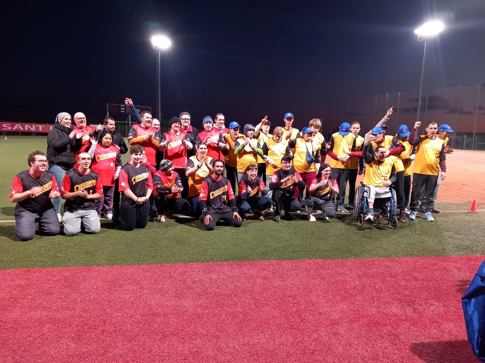 Les persones participants a la Lliga de Softbol Inclusiu celebren el final de la competició al terreny de joc.