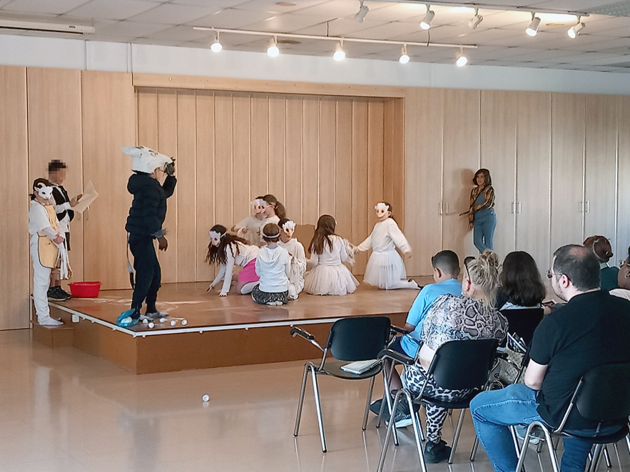 Un grup d'infants amb disfresses de cabretes representa una obra de teatre