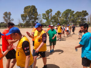 Dos equips que participen a la Lliga de Softbol Inclusiu es saluden amb la ma després del partit