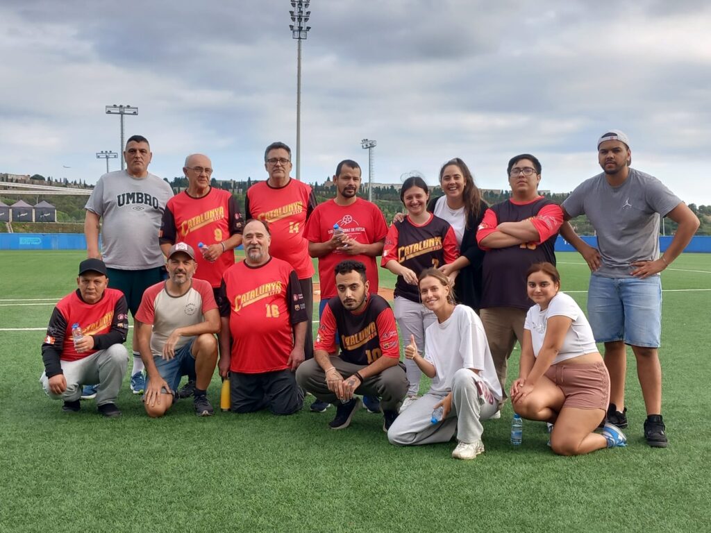 Un grup de persones amb equipació esportiva posant per la càmera en un camp de gespa.