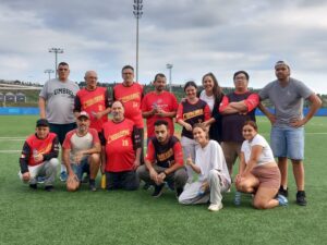 Un grup de persones amb equipació esportiva posant per la càmera en un camp de gespa.
